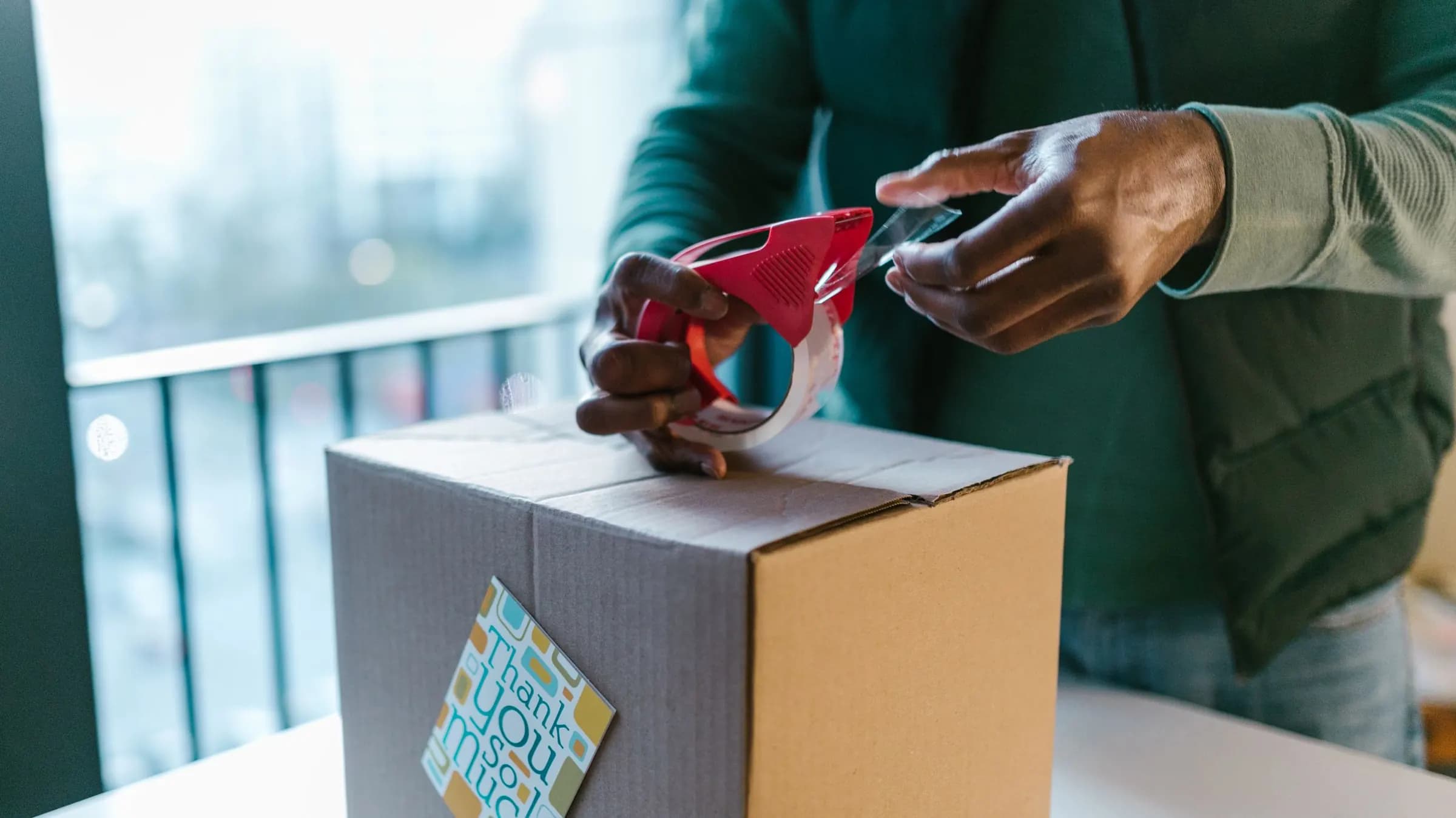 An online order being taped shut in a cardboard box for dispatch.